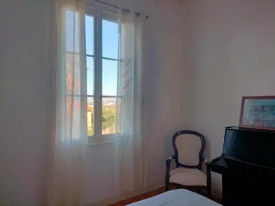 a bedroom with a chair and a window at L'Essentiel à Nice in Nice