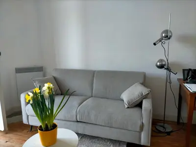 a living room with a couch and a table with flowers at L'Essentiel à Nice in Nice