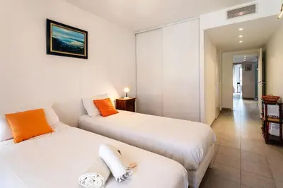 a bedroom with two beds and a room with a table at Jardin Wilson AP4455 by RIVIERA HOLIDAY HOMES in Nice