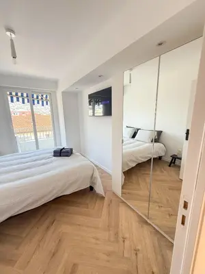 a bedroom with two beds and a large mirror at appartement port de Nice 4pers emplacement idéal in Nice
