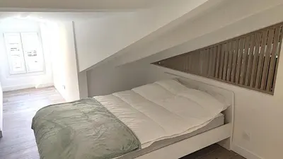 a bed in a white room with a stair case at Gubernatis centre ville in Nice