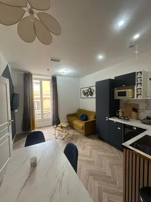 a kitchen and living room with a table and a couch at Appartement 2 chb 1 SDB Nice - 32 in Nice