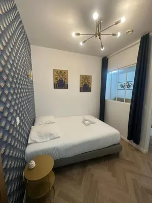 a bedroom with a bed and a table and a window at Appartement 2 chb 1 SDB Nice - 32 in Nice