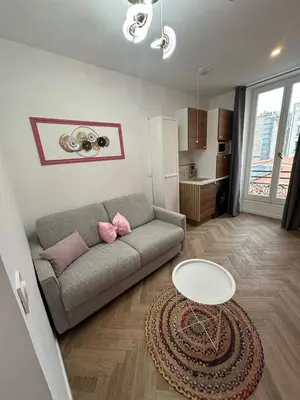 a living room with a couch and a table at MOON - 33 in Nice