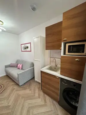 a small kitchen with a couch and a microwave at MOON - 33 in Nice