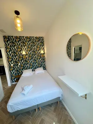 a small bedroom with a bed and a mirror at MOON - 34 in Nice