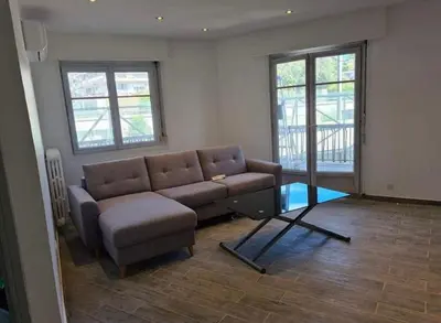 a living room with a couch and two windows at Vacances à Nice in Nice