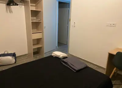 a room with a bed and a desk and a closet at Vacances à Nice in Nice