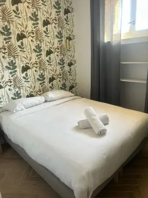 a bed with two towels on top of it at MOON - 35 in Nice