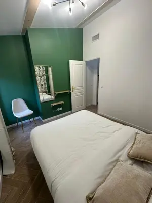 a large bed in a room with a green wall at MOON - 35 in Nice