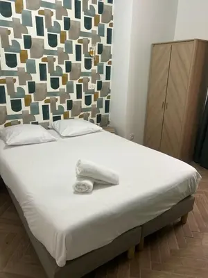 a bed with a white towel on top of it at MASSENA 36 in Nice
