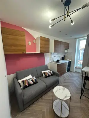 a living room with a couch and a kitchen at MOON - 43 in Nice