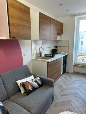 a living room with a couch and a kitchen at MOON - 43 in Nice