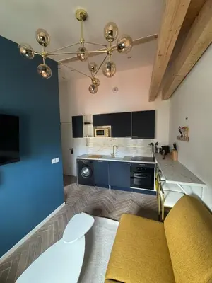 a large kitchen with blue cabinets and a table at MOON - 45 in Nice