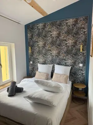 a bedroom with a large bed with a brick wall at MOON - 45 in Nice