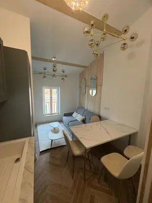 a living room with a table and a blue couch at MOON - 47 in Nice