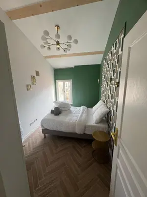 a bedroom with a bed and a green wall at MOON - 47 in Nice