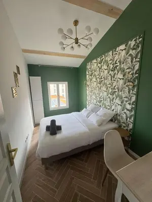 a bedroom with a large bed with a green wall at MOON - 47 in Nice