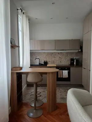a kitchen with a wooden table and a sink at Studio Centre-Ville Nice in Nice