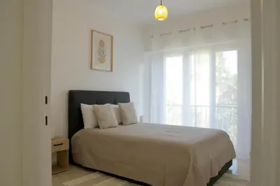 a white bedroom with a bed and a window at Appartement à 5 min de la plage Soleil & Confort in Nice