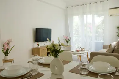 a living room with a table with a vase of flowers at Appartement à 5 min de la plage Soleil & Confort in Nice