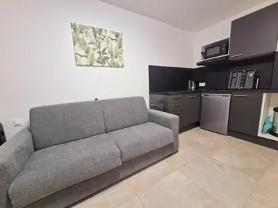 a living room with a couch and a kitchen at appartement 1 pégurier in Nice
