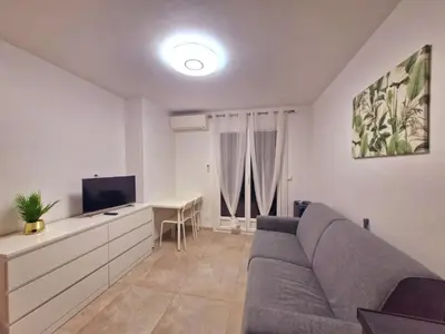 a living room with a gray couch and a desk at appartement 1 pégurier in Nice