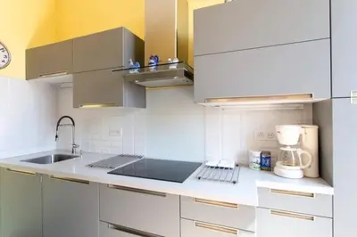 a kitchen with white cabinets and a sink at PANTHEON- App centre, 2 ch, 2 sdb , classé 4 étoiles in Nice