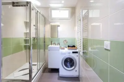 a washing machine in a bathroom with a shower at PANTHEON- App centre, 2 ch, 2 sdb , classé 4 étoiles in Nice