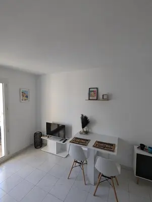 a white living room with a table and chairs at Nice center - 2 person apartment in Nice