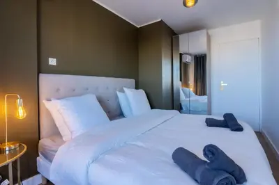 a bedroom with a large white bed with blue towels on it at Le Sunrise in Nice