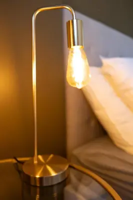 a lamp sitting on a table next to a bed at Le Sunrise in Nice