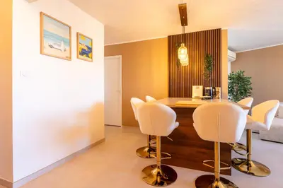 a dining room with white chairs and a wooden table at Le Sunrise in Nice