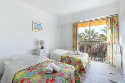 a bedroom with two beds and a window at Happyfew appartement les palmiers in Nice