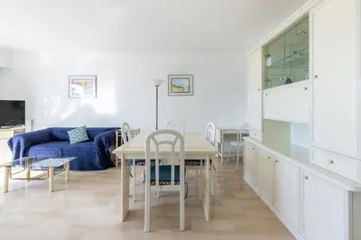 a living room with a table and a blue couch at Happyfew appartement les palmiers in Nice