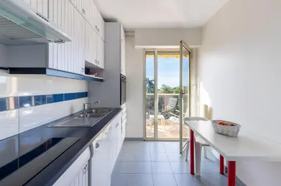 a white kitchen with a sink and a counter at Happyfew appartement les palmiers in Nice