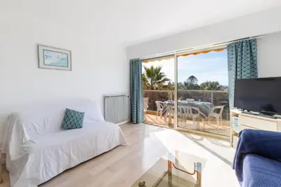 a living room with a white couch and a tv at Happyfew appartement les palmiers in Nice