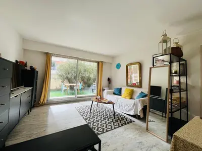 a living room with a couch and a table at Appartement avec grande terrasse in Nice