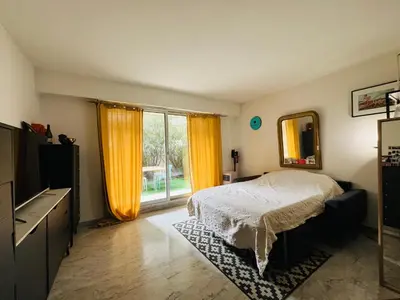 a bedroom with a bed and a large window at Appartement avec grande terrasse in Nice