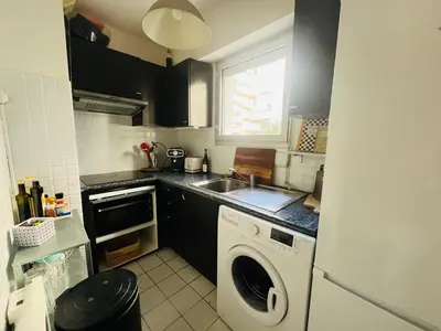 a kitchen with a washing machine and a sink at Appartement avec grande terrasse in Nice