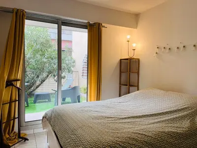 a bedroom with a bed and a large window at Appartement avec grande terrasse in Nice