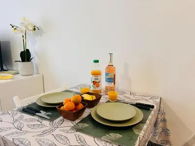 a table with two plates and oranges and bottles of juice at Coeur de Nice in Nice