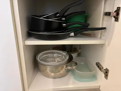 a cabinet filled with pans and other kitchen utensils at Coeur de Nice in Nice