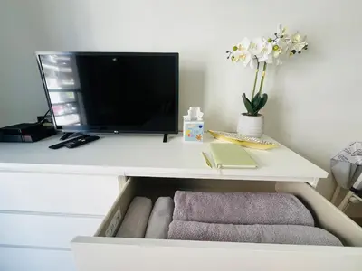a desk with a tv and a drawer with towels at Coeur de Nice in Nice