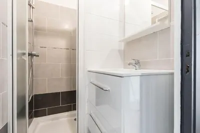 a white bathroom with a sink and a shower at Noa house in Nice