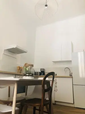 a kitchen with a table and a refrigerator at Noa house in Nice