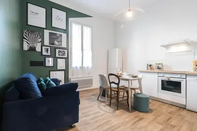 a living room with a couch and a kitchen with a table at Noa house in Nice