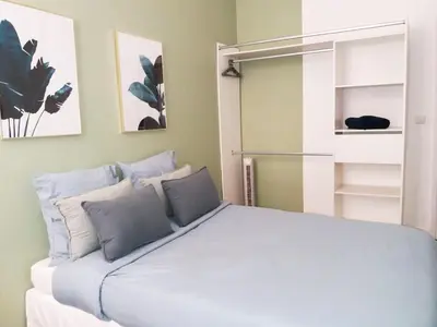 a bedroom with a large bed and a refrigerator at Noa house in Nice