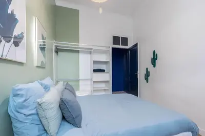 a bedroom with a white bed with blue pillows at Noa house in Nice