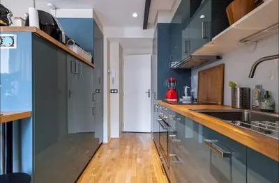 a kitchen with blue cabinets and a wooden floor at Duplex center of Nice with AC in Nice